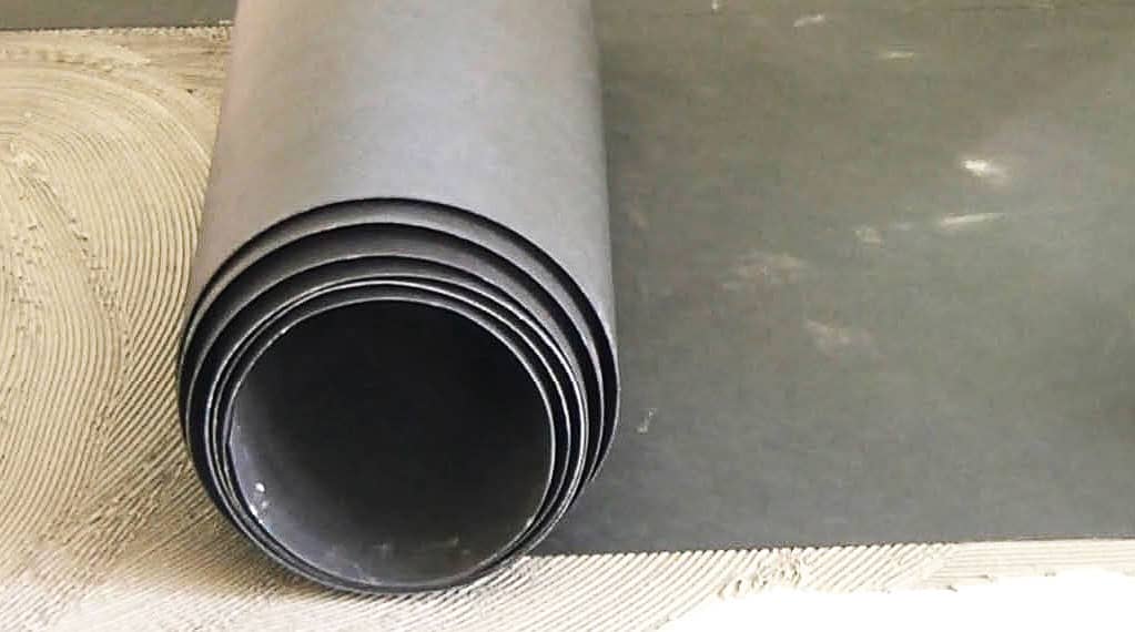 Lámina anti-impacto colocada bajo recrecido de suelo para reducción de ruido de pisadas